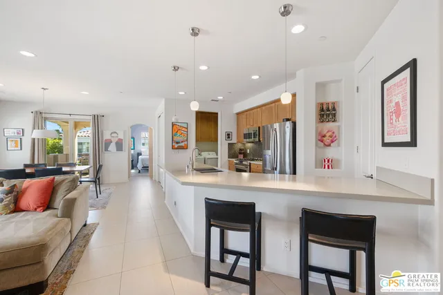 a large kitchen with stainless steel appliances kitchen island a large counter top and a refrigerator