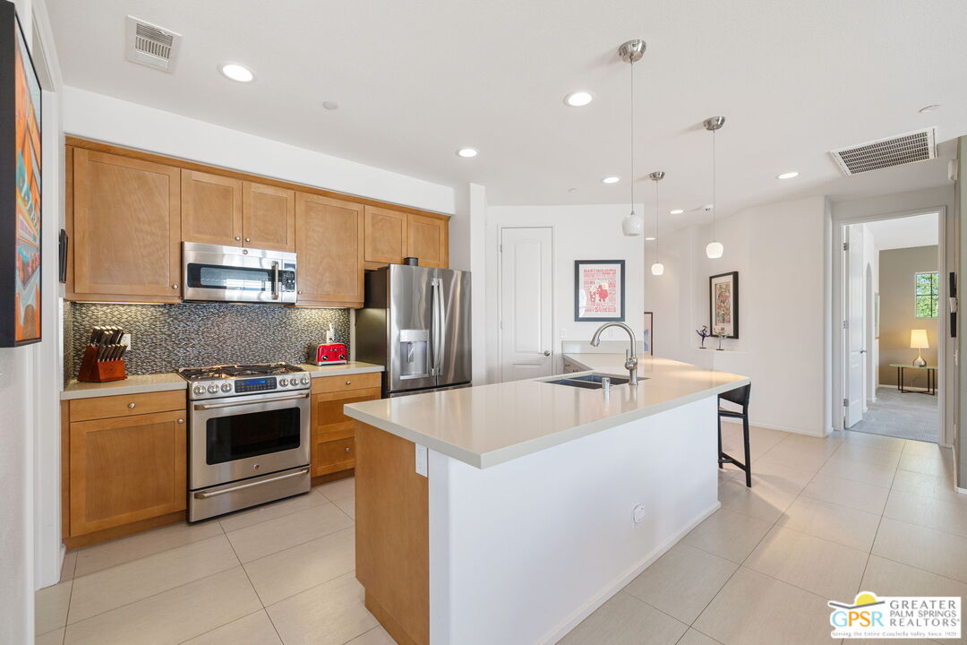 491 Terra Vita Palm Springs, CA 92262 - Photo 12 of 25 a large kitchen with stainless steel appliances kitchen island a large counter top and a refrigerator