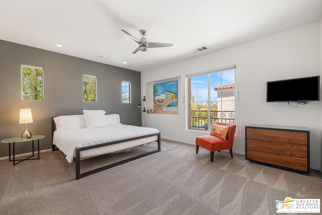 491 Terra Vita Palm Springs, CA 92262 - Photo 17 of 25 a spacious bedroom with a bed and a flat screen tv