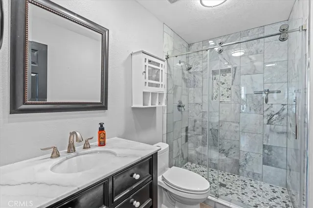 a bathroom with a sink a toilet and shower