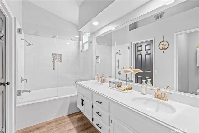 a bathroom with a tub a sink double vanity and shower