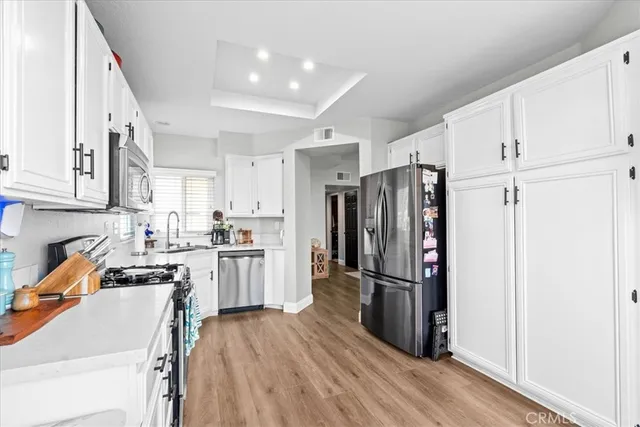 a kitchen with stainless steel appliances granite countertop a refrigerator stove and wooden floor