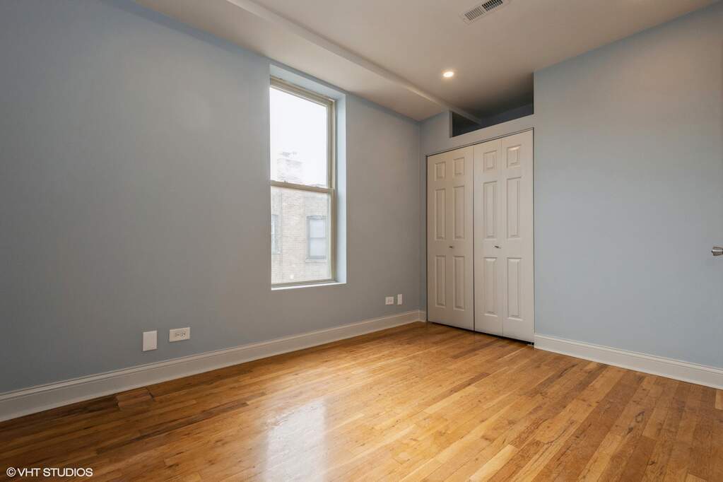 1446 West Irving Park Road, Unit 2 Chicago, IL 60613 - Photo 14 of 23 an empty room with wooden floor and windows