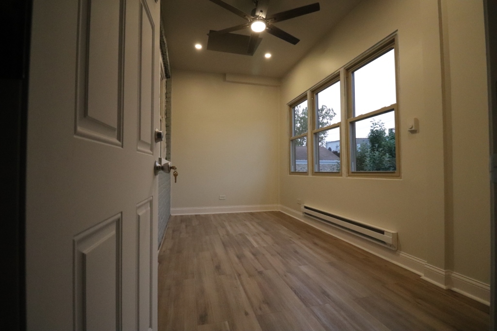 1446 West Irving Park Road, Unit 2 Chicago, IL 60613 - Photo 18 of 23 an empty room with wooden floor and windows