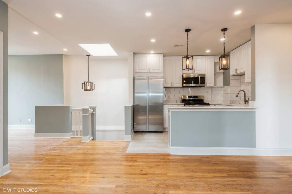 1446 West Irving Park Road, Unit 2 Chicago, IL 60613 - Photo 7 of 23 a view of kitchen with stainless steel appliances refrigerator stove microwave and cabinets