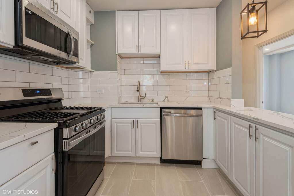 1446 West Irving Park Road, Unit 2 Chicago, IL 60613 - Photo 8 of 23 a kitchen with stainless steel appliances granite countertop white cabinets a stove a sink and dishwasher