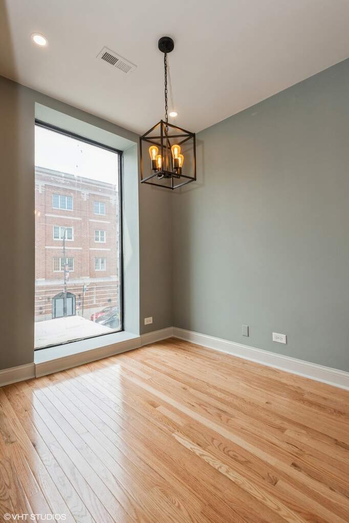 1446 West Irving Park Road, Unit 2 Chicago, IL 60613 - Photo 9 of 23 a view of an empty room with wooden floor and a window