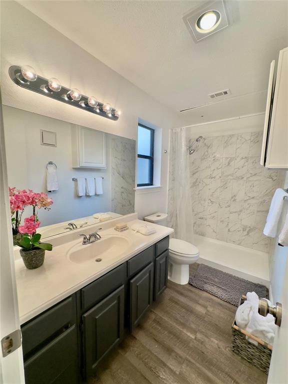 7340 Skillman Street, Unit 405 Dallas, TX 75231 - Photo 6 of 18 Bathroom featuring a single vanity with dark cabinetry, integrated sink, and chrome faucet