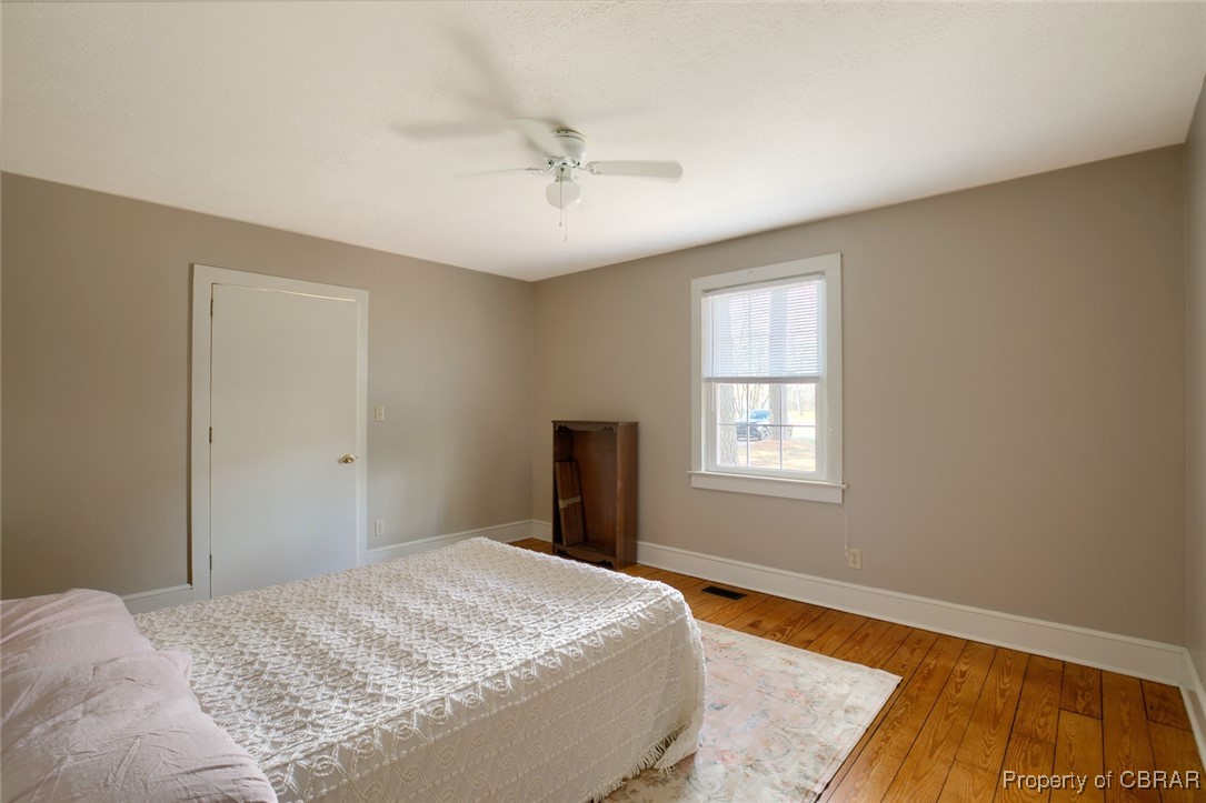 10371 Buckley Hall Road Mathews, VA 23109 - Photo 16 of 28 Bedroom featuring baseboards, ceiling fan, visible vents, and light wood-type flooring