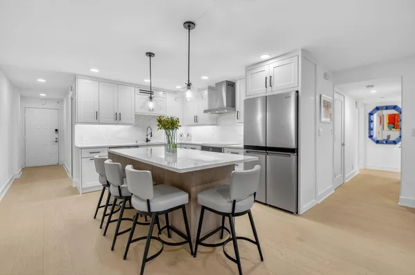 a kitchen with stainless steel appliances kitchen island a refrigerator and a dining table