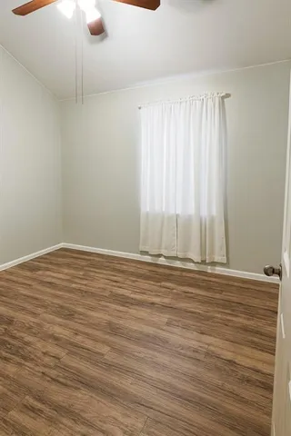 a view of a room with wooden floor and fan