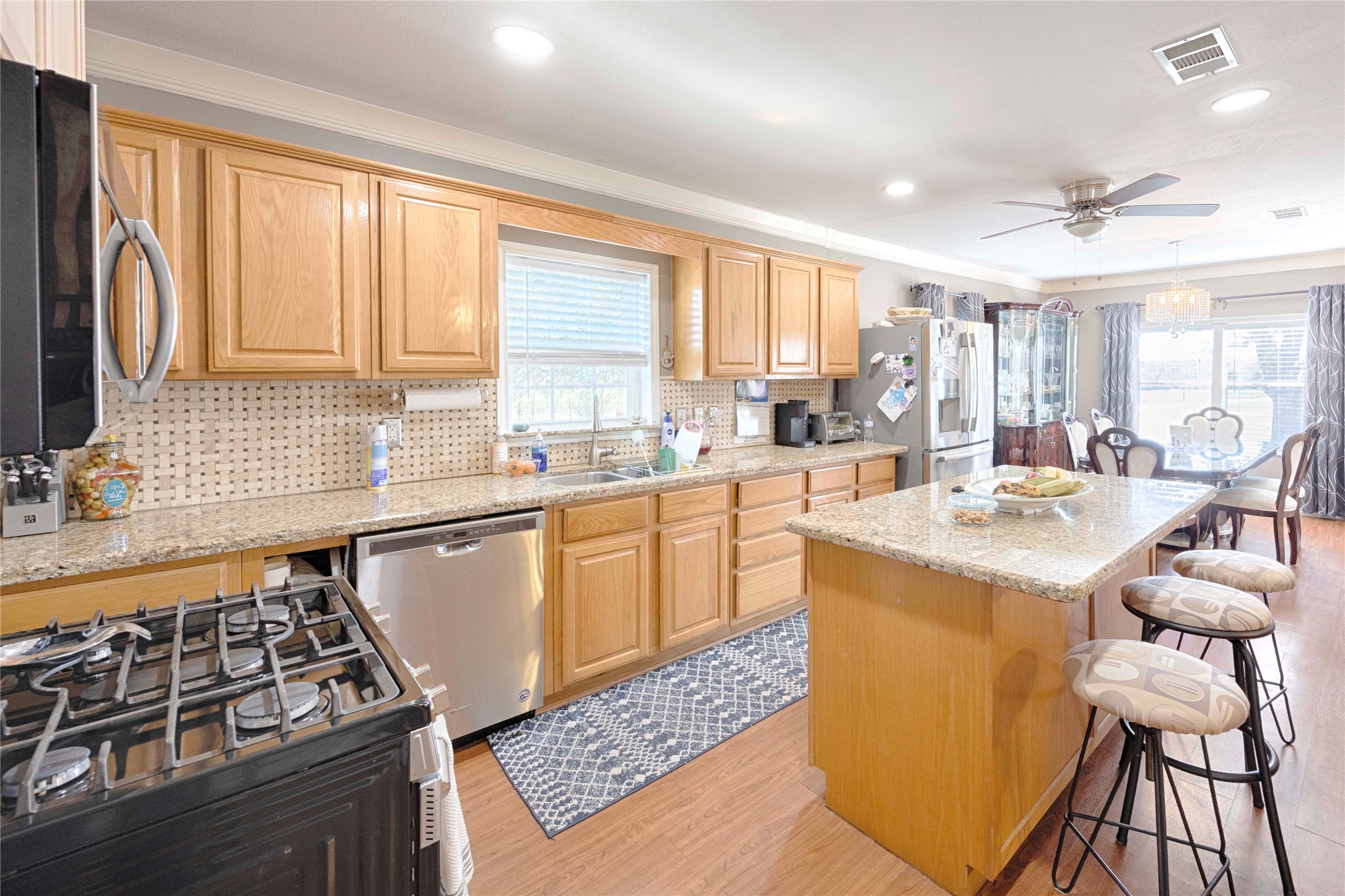 5135 Highway 90 Schulenburg, TX 78956 - Photo 13 of 32 a kitchen with stainless steel appliances kitchen island granite countertop a sink stove and cabinets