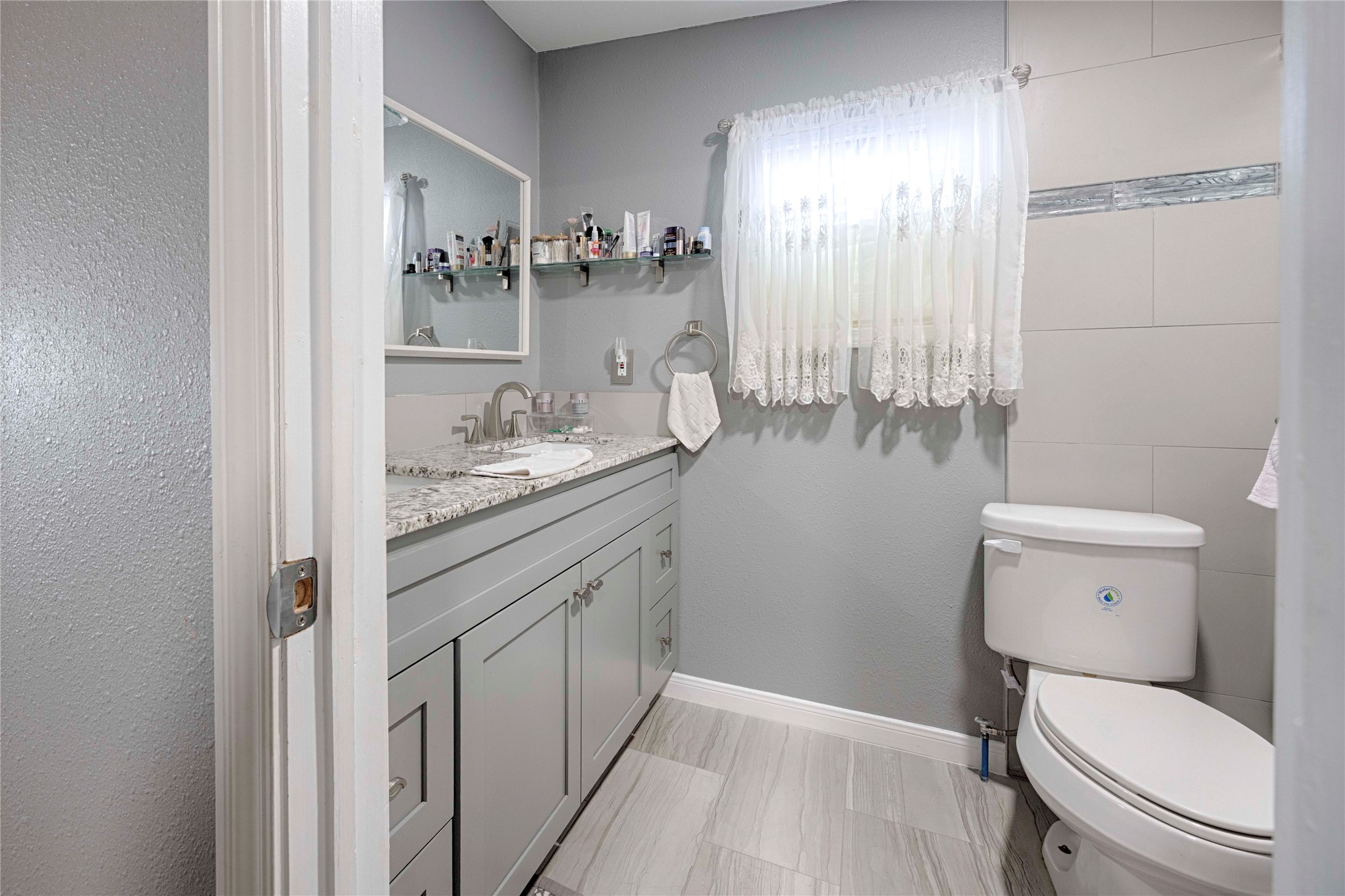 5135 Highway 90 Schulenburg, TX 78956 - Photo 19 of 32 a bathroom with a granite countertop sink a toilet and a mirror