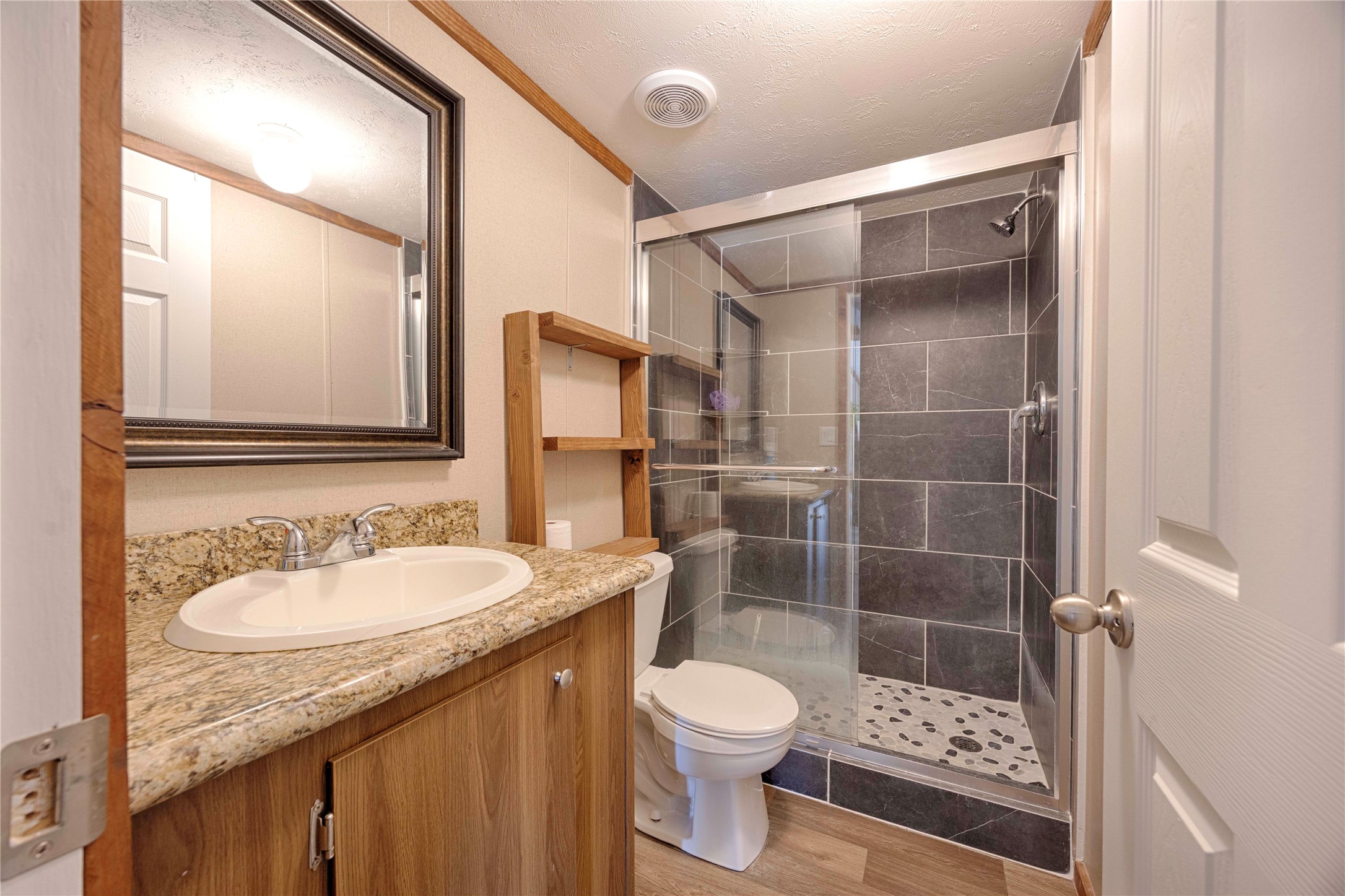 5135 Highway 90 Schulenburg, TX 78956 - Photo 25 of 32 a bathroom with a granite countertop sink toilet and shower