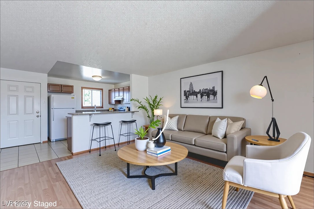 Living room featuring a textured ceiling and light wood-style flooring