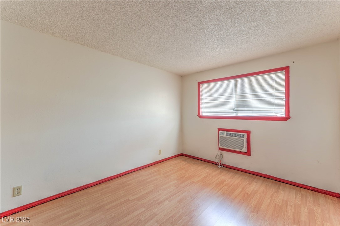 5404 South Swenson Street, Unit 34 Las Vegas, NV 89119 - Photo 17 of 28 Empty room featuring light wood-type flooring and a textured ceiling