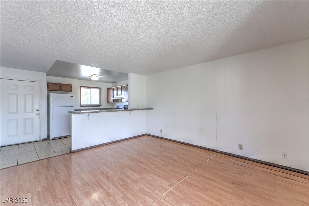 5404 South Swenson Street, Unit 34 Las Vegas, NV 89119 - Photo 5 of 28 Living room featuring a textured ceiling and light wood-style flooring