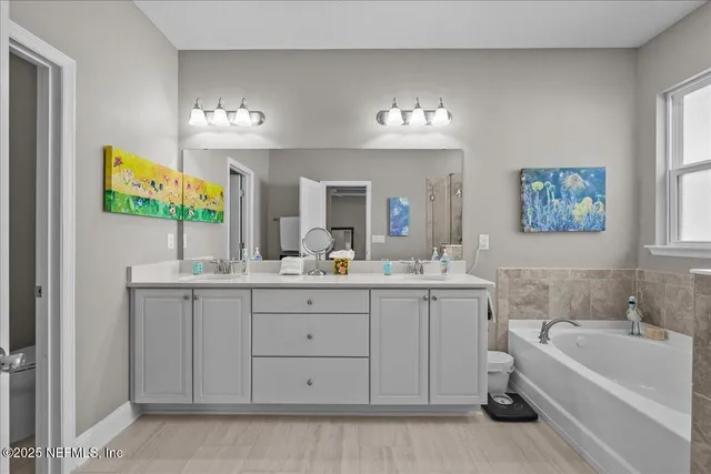 a bathroom with a tub sink and mirror