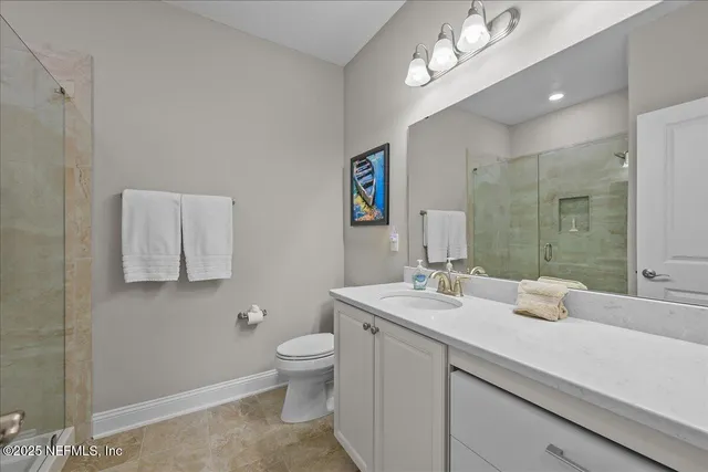 a bathroom with a double vanity sink a toilet and a mirror