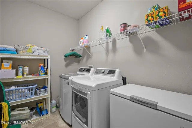 a utility room with fridge dryer and washer