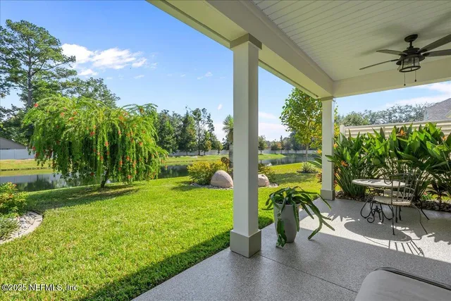 a view of a patio with table and chairs potted plants and palm tree