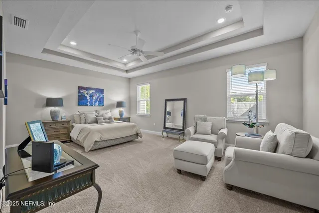 a spacious bedroom with a bed a couch and a dresser with wooden floor