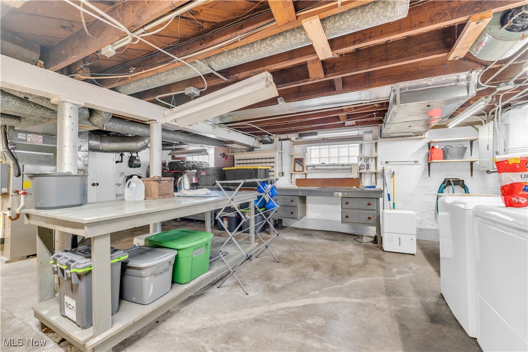 3729 Grosvenor Road Cleveland, OH 44118 - Photo 36 of 39 Basement with electric panel, a workshop area, and washing machine and dryer