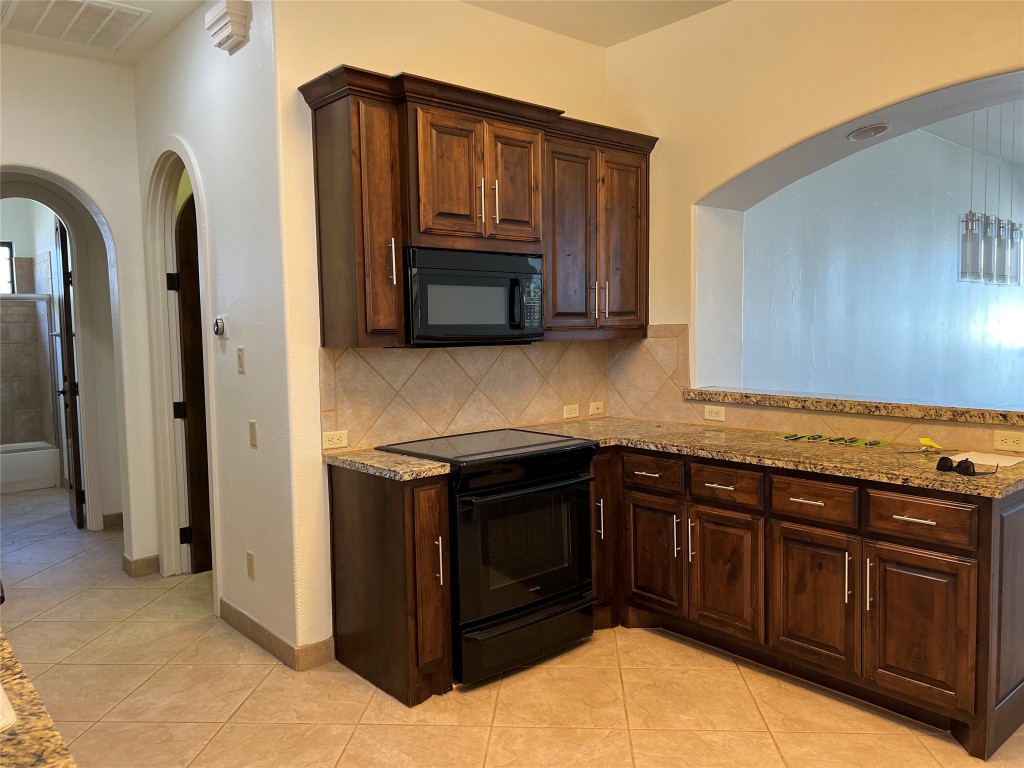 Undisclosed Address Austin, TX 78734 - Photo 12 of 21 a kitchen with stainless steel appliances granite countertop a stove a sink and a microwave
