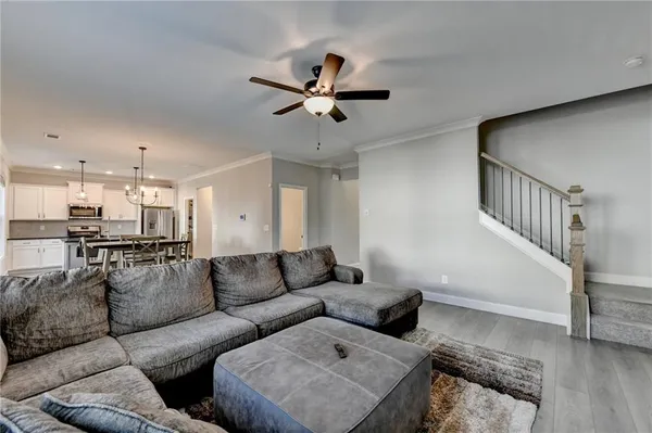 a living room with furniture and a ceiling fan