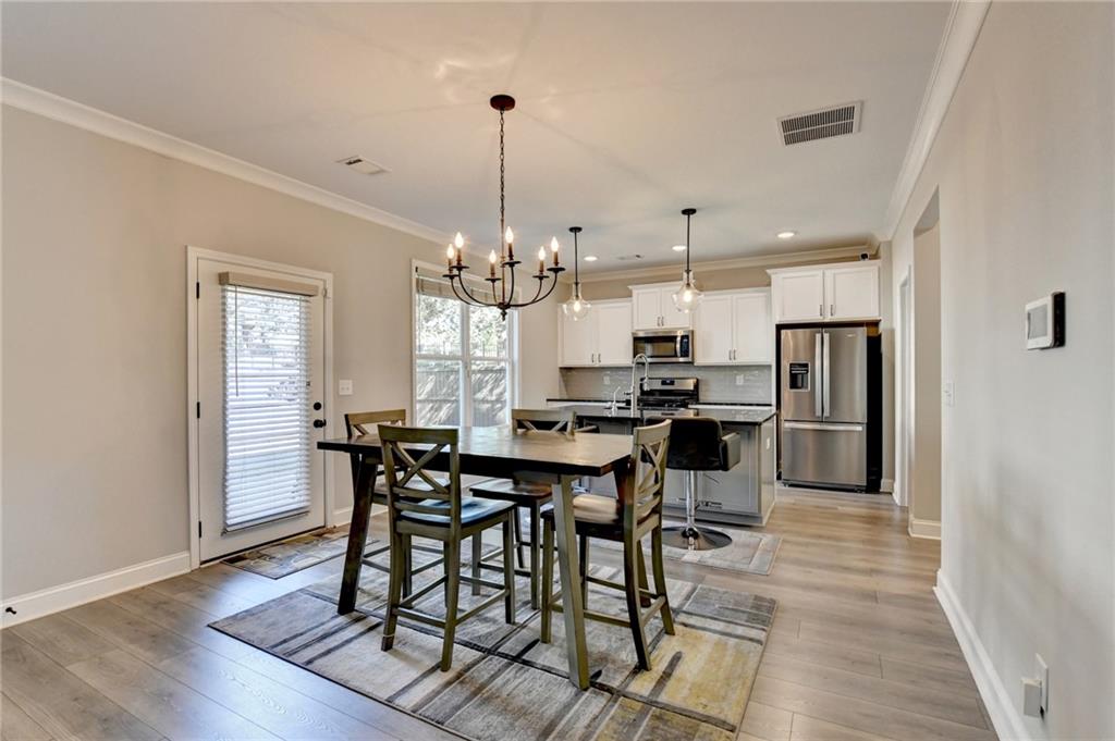 619 Garner Street Buford, GA 30518 - Photo 14 of 45 a view of a dining room and livingroom with furniture wooden floor a rug a chandelier