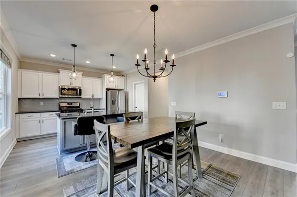 a kitchen with a dining table chairs stainless steel appliances and cabinets