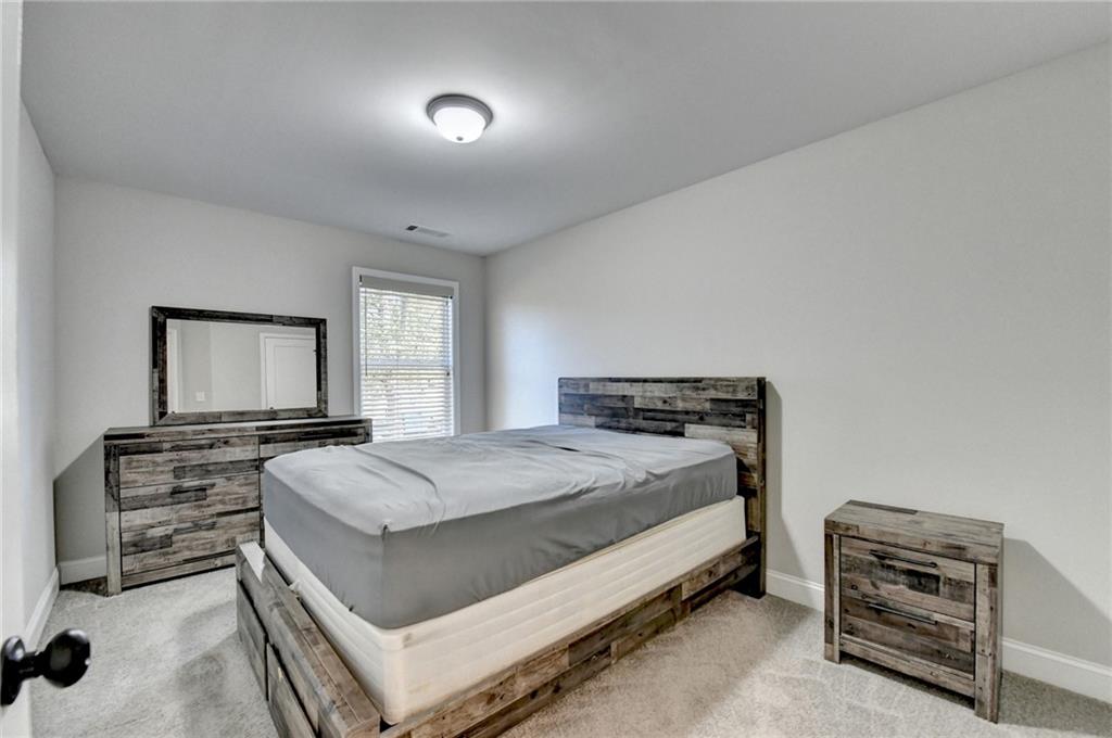 619 Garner Street Buford, GA 30518 - Photo 25 of 45 a bedroom with a bed and a flat screen tv