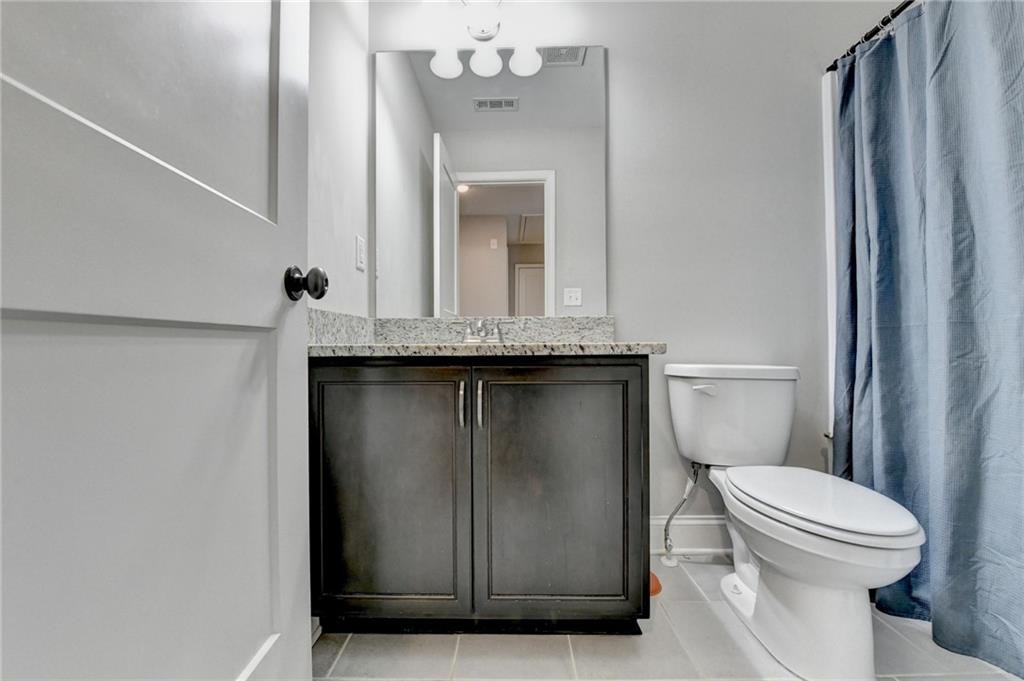 619 Garner Street Buford, GA 30518 - Photo 32 of 45 a bathroom with a granite countertop sink a toilet and mirror