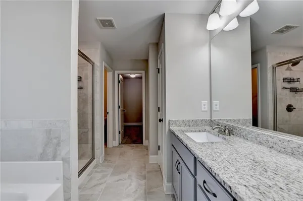 a bathroom with a granite countertop sink a mirror and a bathtub