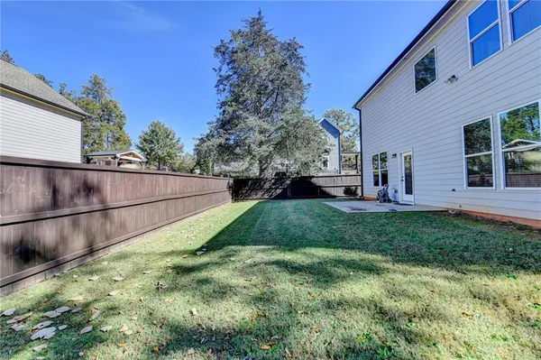 a view of a backyard with plants and large tree
