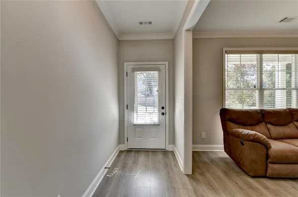 an empty room with wooden floor and windows