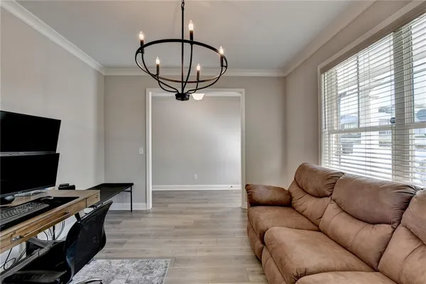 a living room with furniture a flat screen tv and a window