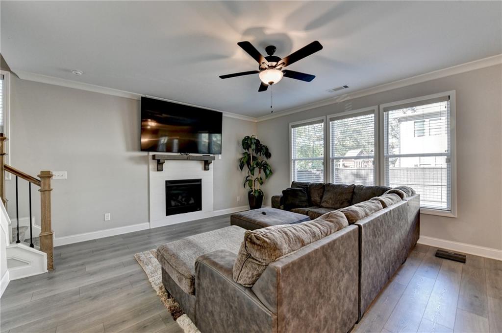 619 Garner Street Buford, GA 30518 - Photo 8 of 45 a living room with furniture a flat screen tv and a fireplace
