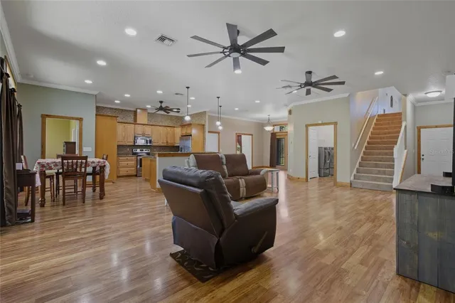 a kitchen with stainless steel appliances granite countertop a sink a stove and a wooden floors