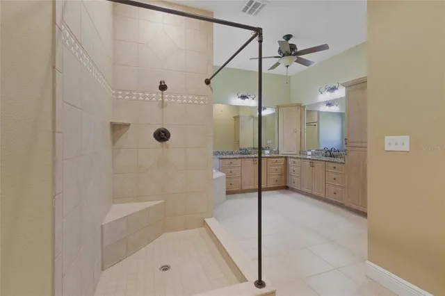 a spacious bathroom with a granite countertop sink mirror and a bathtub