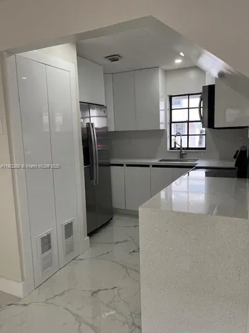 a kitchen with stainless steel appliances granite countertop a refrigerator and a sink