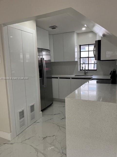 a kitchen with stainless steel appliances granite countertop a refrigerator and a sink