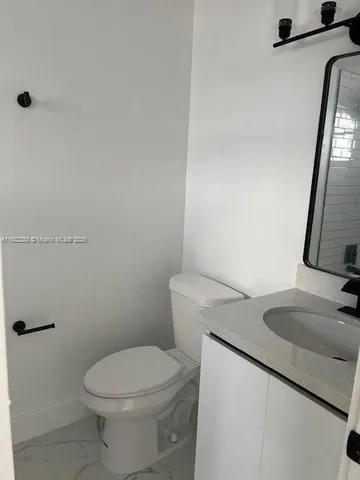 a white toilet sitting next to a bathroom sink