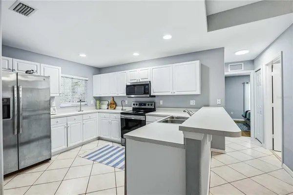 a kitchen with a sink a refrigerator and cabinets