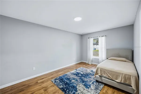 a bedroom with a bed and wooden floor