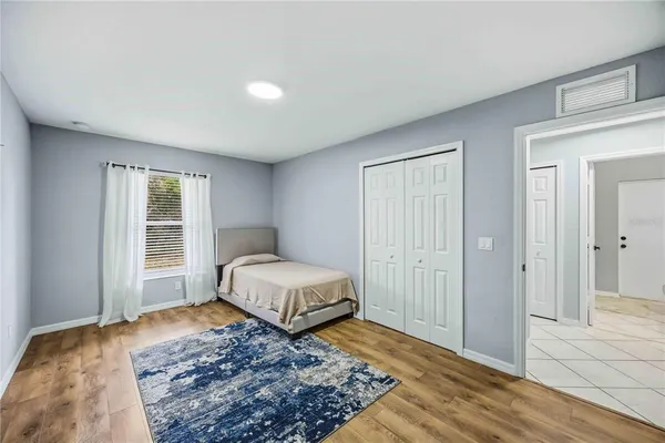a bedroom with a bed and wooden floor