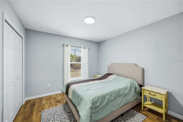 a bedroom with a bed and wooden floor