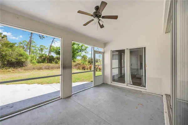 a view of an empty room with a window and a kitchen area