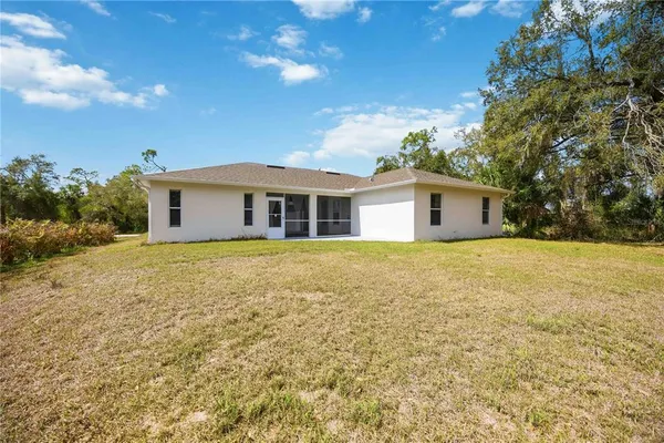 a front view of house with yard and trees in the background