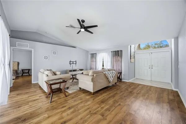 a living room with furniture and a wooden floor